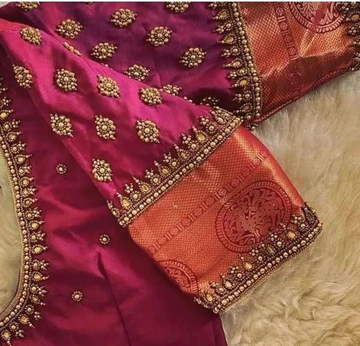 Magenta silk blouse close-up showing Aari gold bead motifs, teardrop stones and contrasting zari woven sleeve border