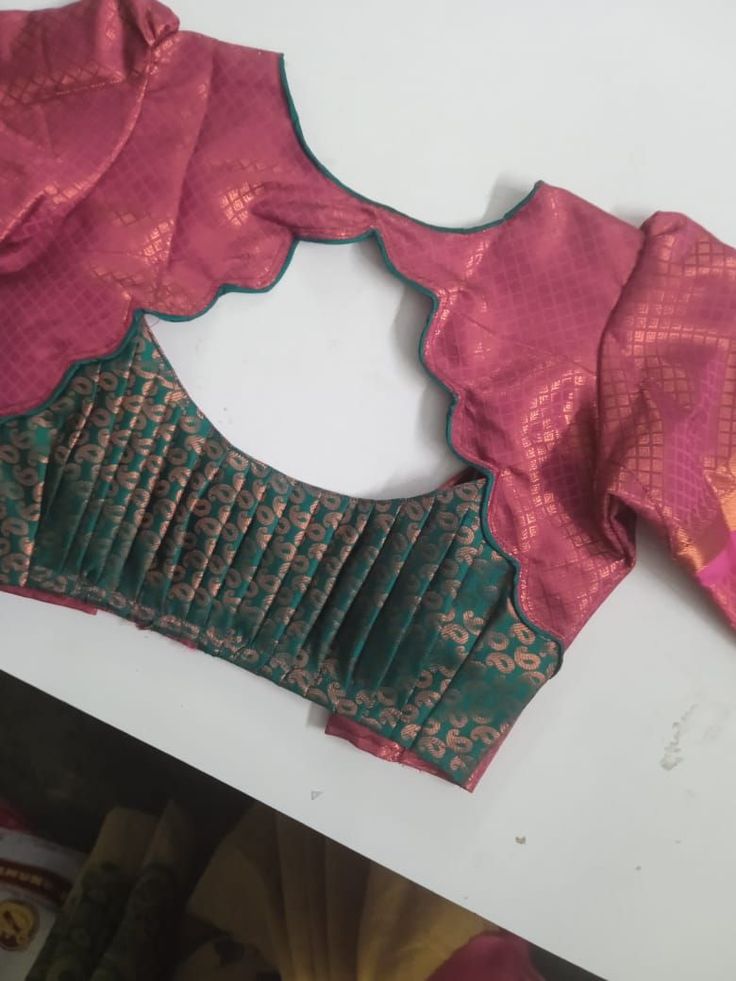 Magenta and green designer blouse back with circular scalloped cutout and pleated paisley panel