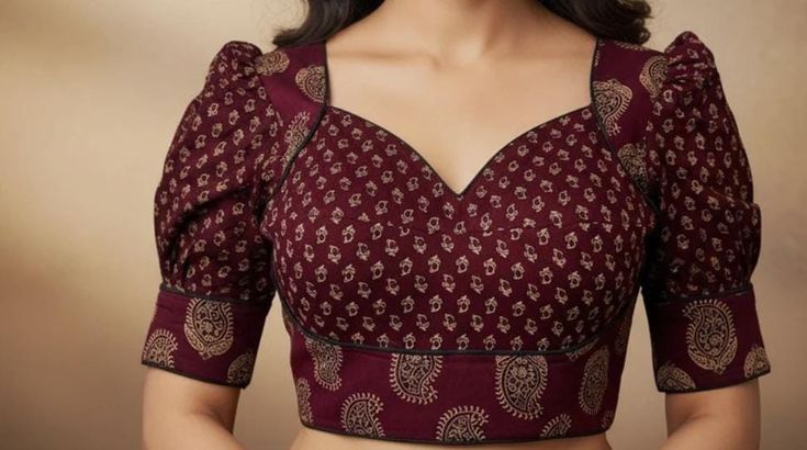 Maroon princess-cut blouse with gold paisley print, sweetheart neck, black piping and puff sleeves