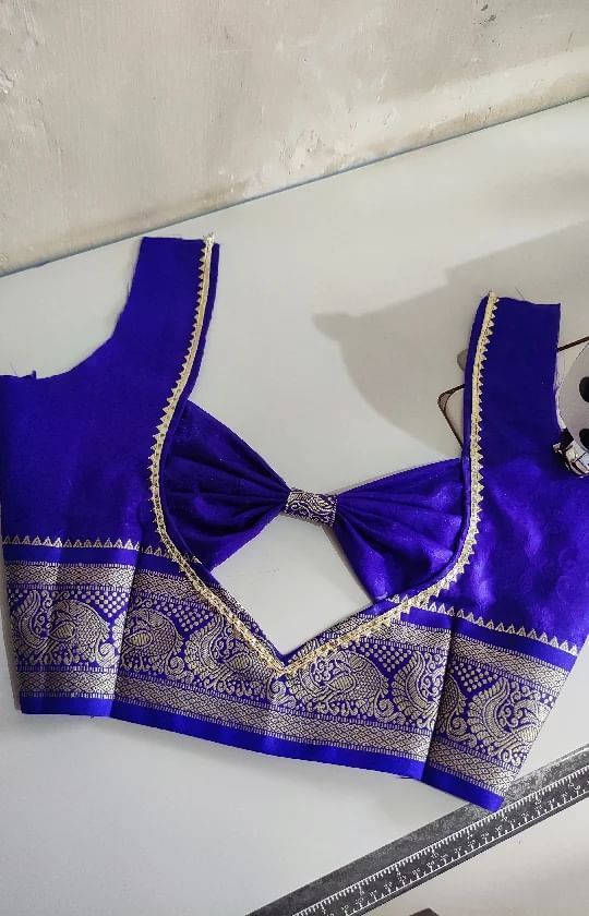 Royal blue saree blouse back with fabric bow, V-cutout and wide peacock zari border
